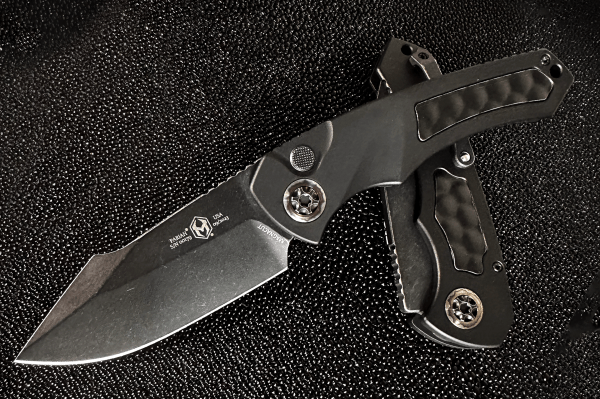A photo of the Heretic Knives Pariah auto featuring a DLC single edge blade, black handle, and black bubble inlay.